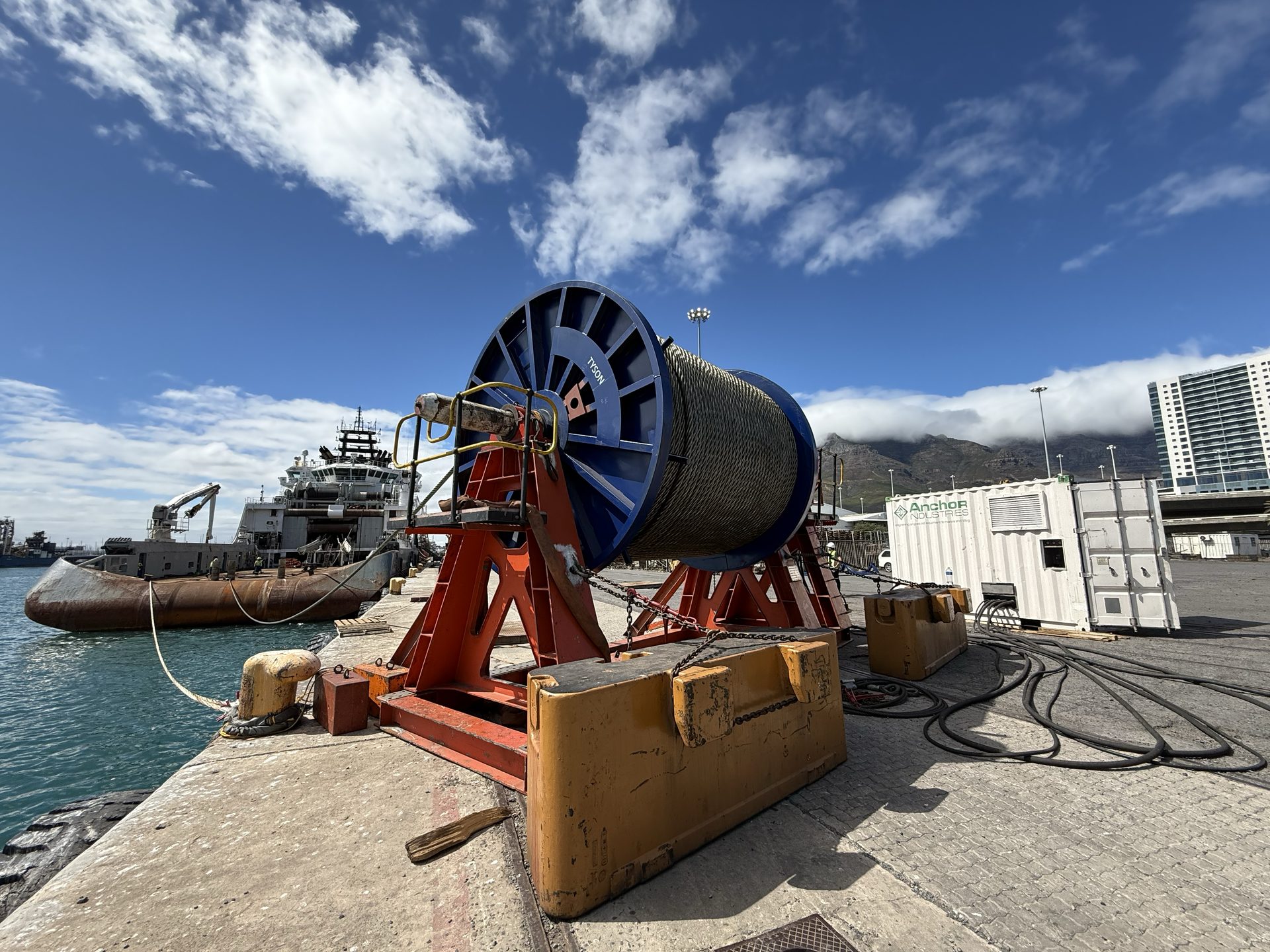 Subsea cable reel on a tensioning spread at the quayside in the Port of Cape Town, an offshore supply vessel alongside – Afrishore integrated logistics and project cargo, South Africa